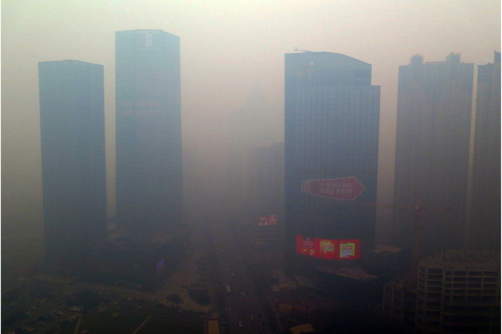 This picture taken on 8 November 2015 shows a residential block shrouded in smog in Shenyang, Liaoning province