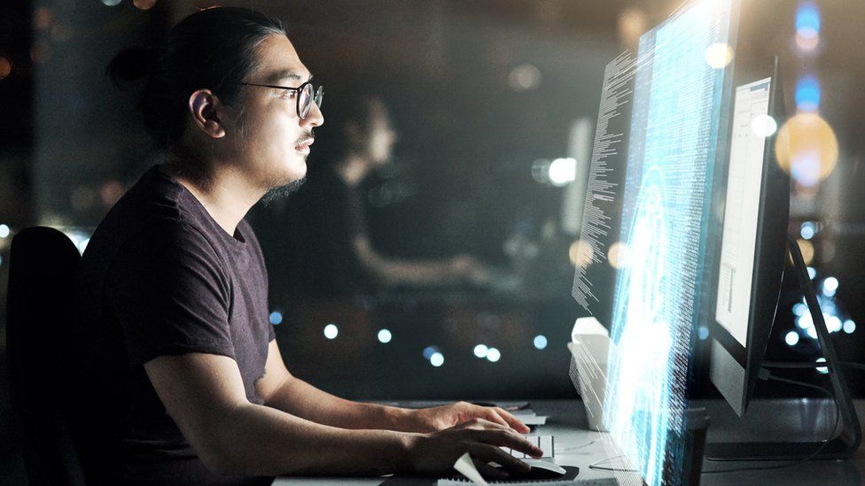 Снимок человека за терминалом, работающего над компьютерным кодом