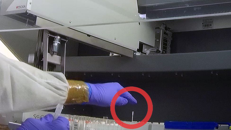 Technician pops swab snagged by pipette robot back into tube