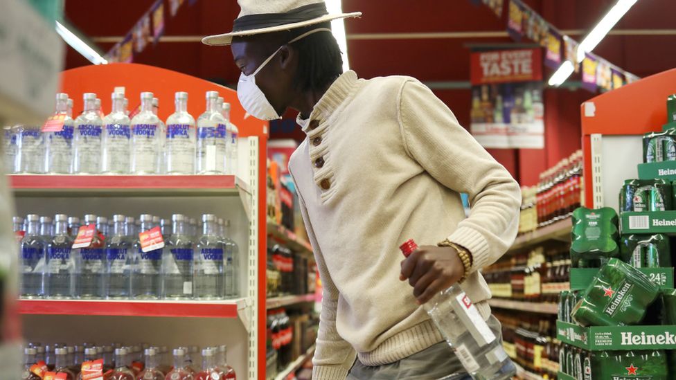 A man holding a vodka bottle in supermarket in Soweto, South Africa - June 2020
