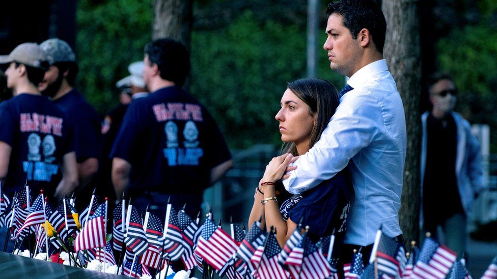 Katie Mascali is comforted by her fiance Andre Jabban as they stand near the name of her father Joseph Mascali, with FDNY Rescue 5, commemorating September 11 attacks, in Manhattan, New York City, U.S., September 11, 2021