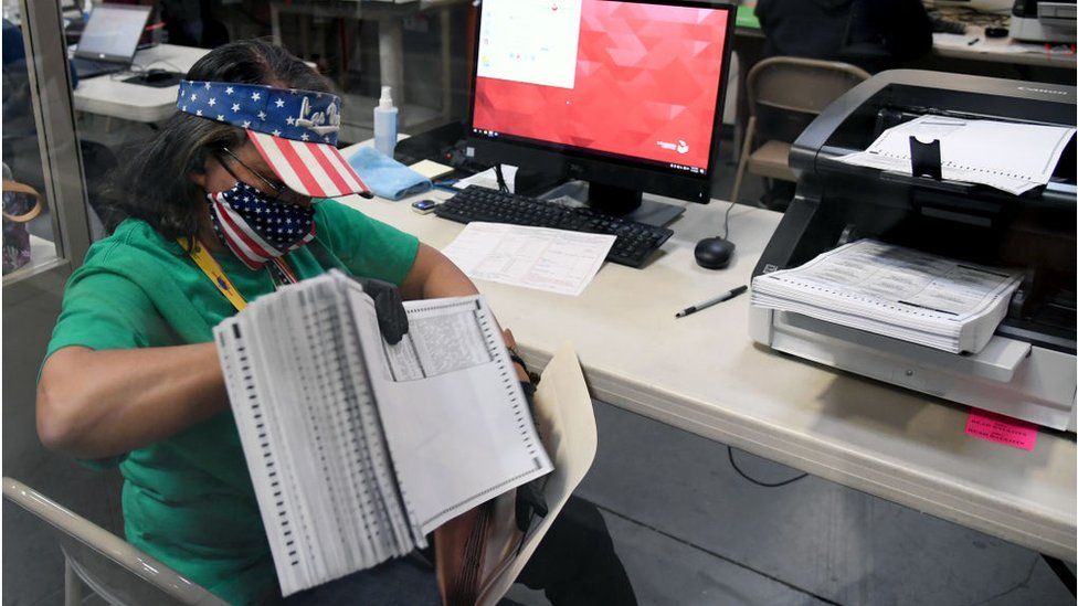 An election worker in Nevada counts mail-in ballots