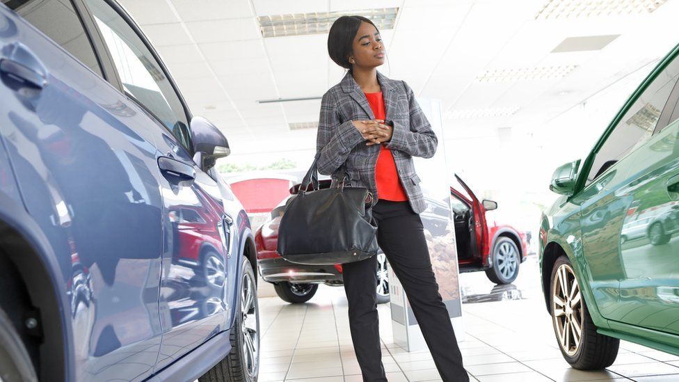 Woman looking at cars in showroom