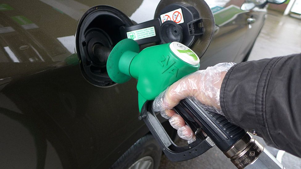 Hand filling a car with petrol