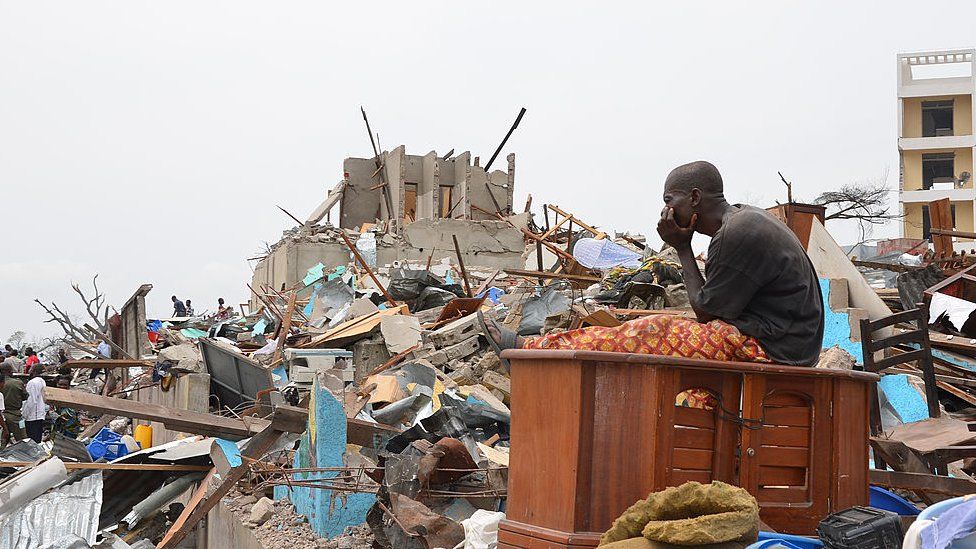 A man sits among the debris left by the explosion at the Mpila district of Brazzaville on March 5, 2012