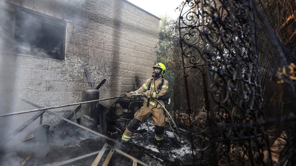 A firefighter works inside the Israeli village of Givat Yearim during a wildfire (16 August 2021)