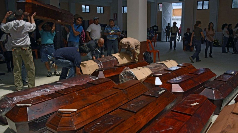 People carry coffins donated for the victims of Thursday's landslide at the village of El Cambray II, in Santa Catarina Pinula municipality, some 15 km east of Guatemala City, on October 3, 2015.