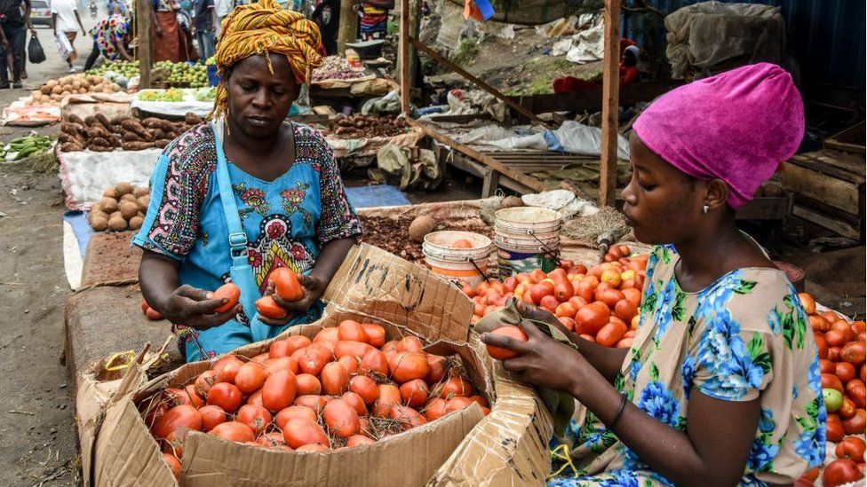 Vendors clean tomatoes on Mabibo Street without without wearing masks despite the confirmed COVID-19 coronavirus cases in Dar es Salaam, Tanzania, on April 16, 2020