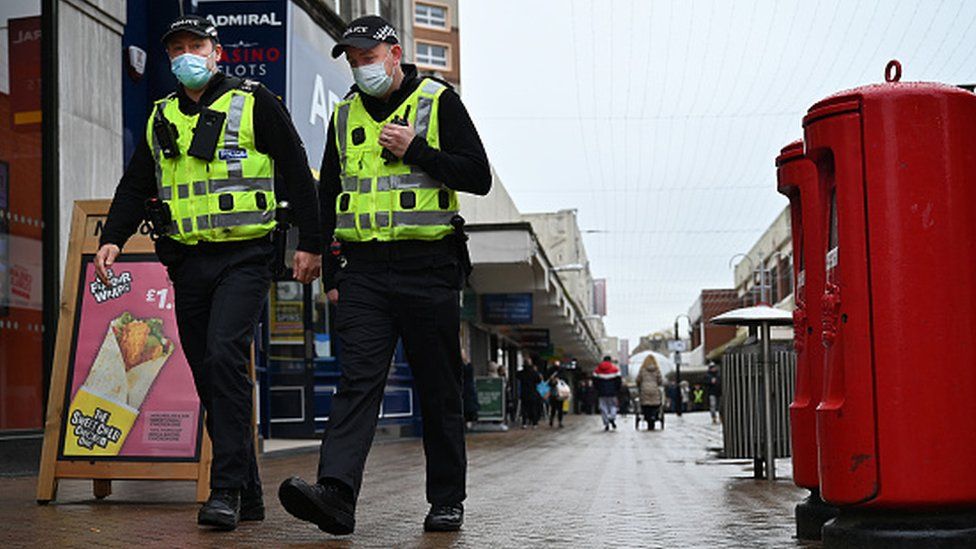 Police officers walk through the town centre in Motherwell, Scotland