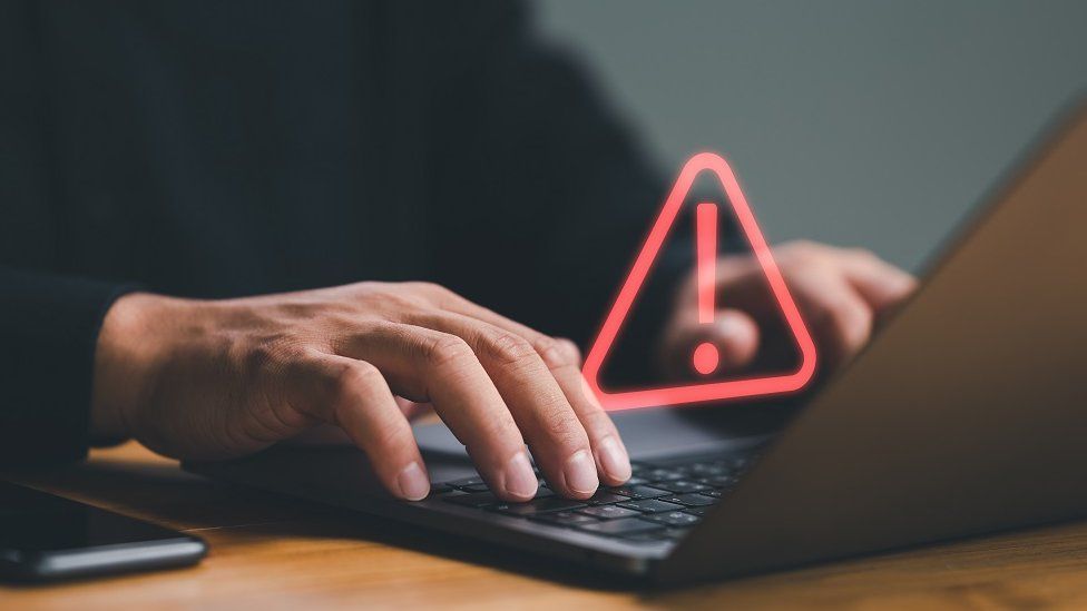 Data breach hand over warning sign laptop