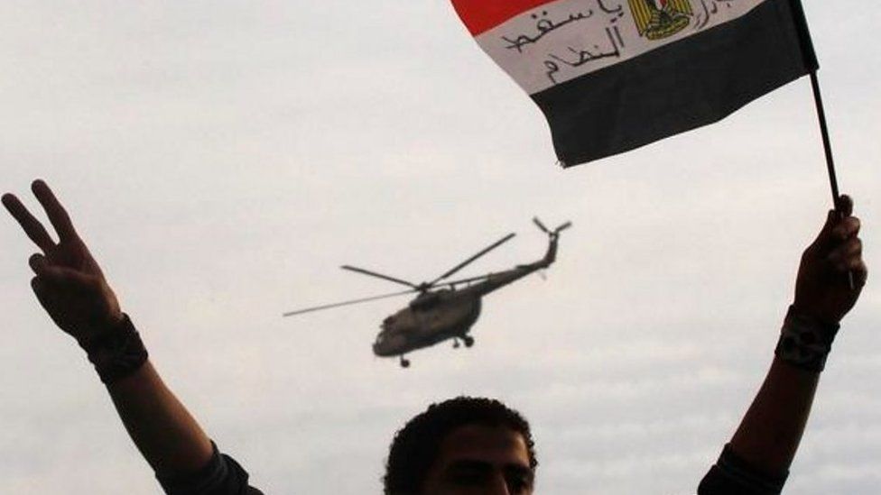 Man waves Egyptian flag as helicopter flies overhead (file photo)