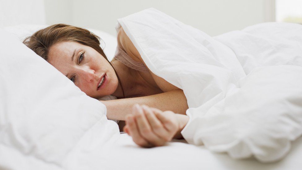 Sick woman with flu lying in bed