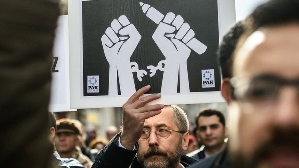 Journalists shout slogans and hold placards on 10 January 2016 as they protest against the imprisonment of journalists