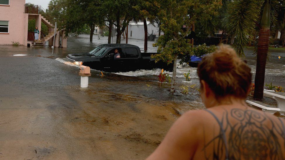 A truck passes through flooded streets caused by Hurricane Idalia passing offshore on 30 August 2023 in Tarpon Springs, Florida