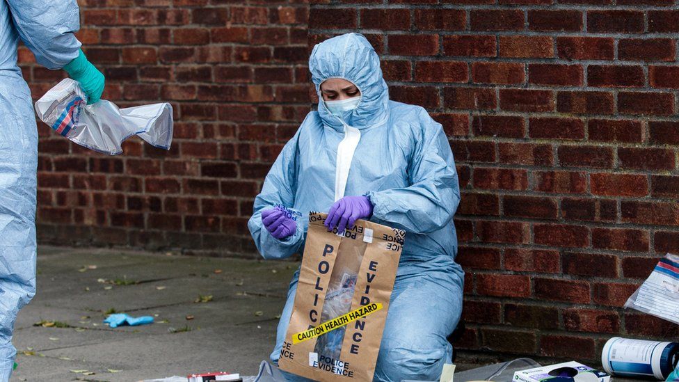 Forensic worker seals up evidence in bag