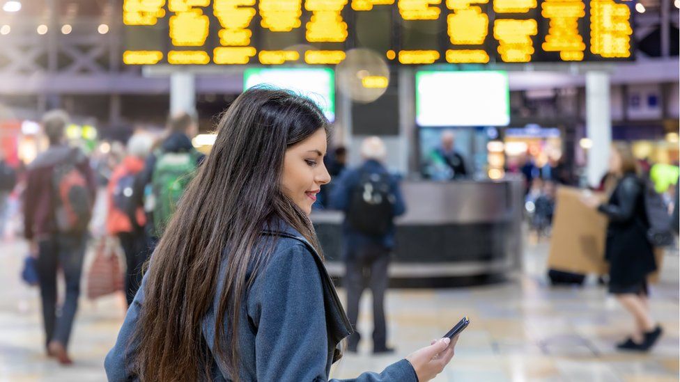 woman on phone at train station