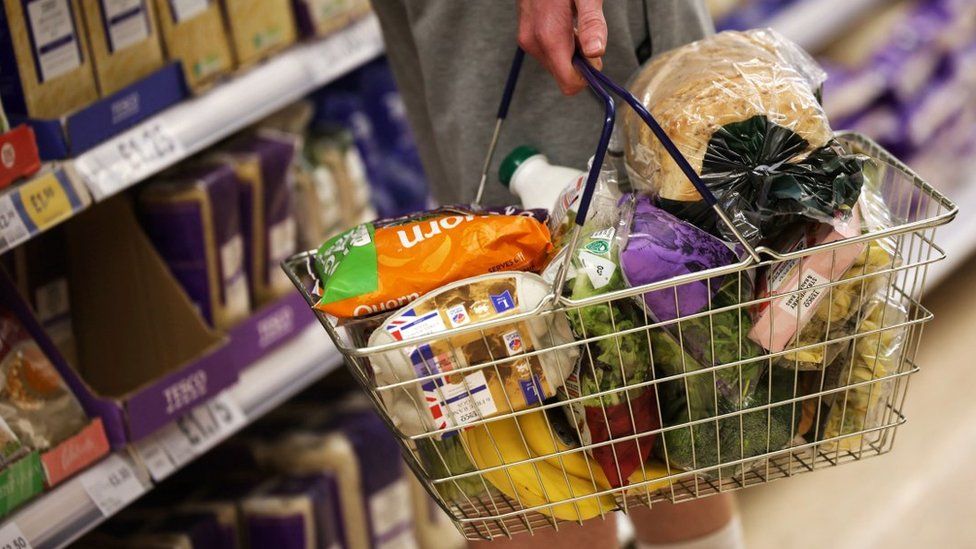 File image of an anonymous man in a London supermarket with a basket of food, including eggs and bread