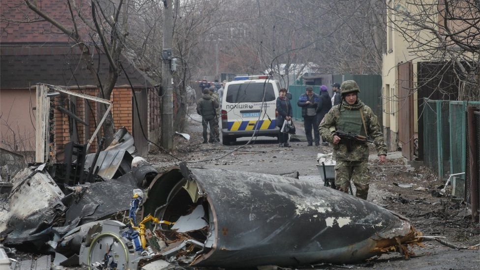 A soldier walks past the debris of a military plane that was shot down overnight in Kiev, Ukraine, 25 February 2022