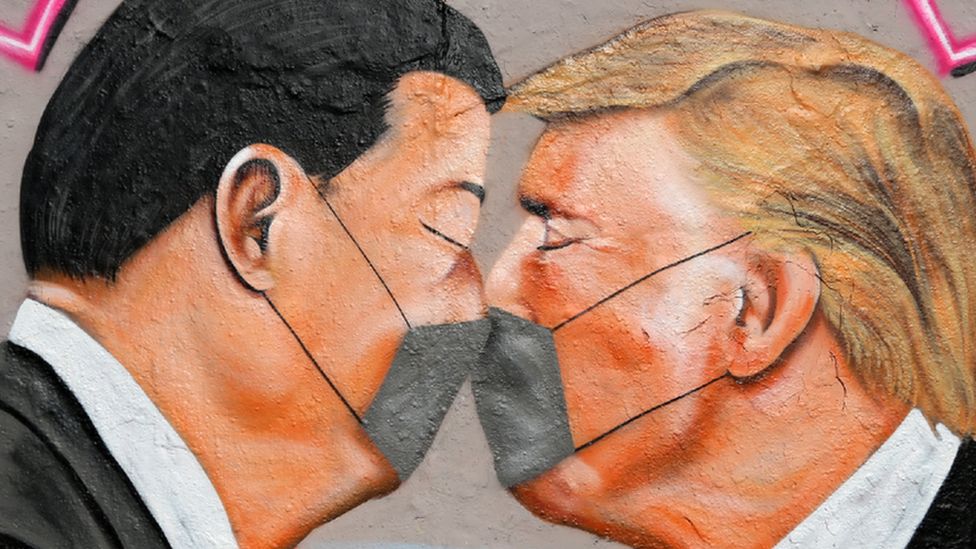 Graffiti showing US President Donald Trump (R) and Chinese President Xi Jinping facing each other in masks