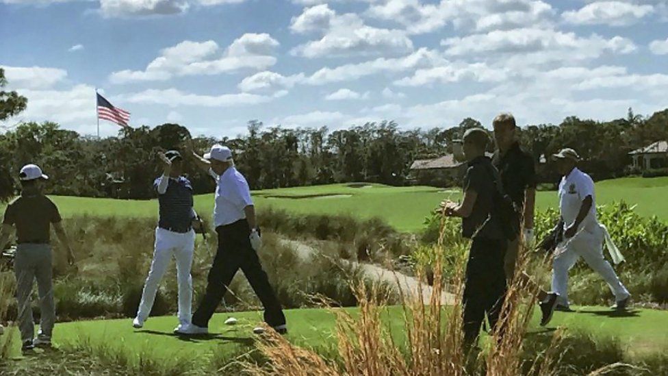 US President Donald Trump high-fives Japan's Prime Minister Shinzo Abe while playing golf in Florida on February 11, 2017