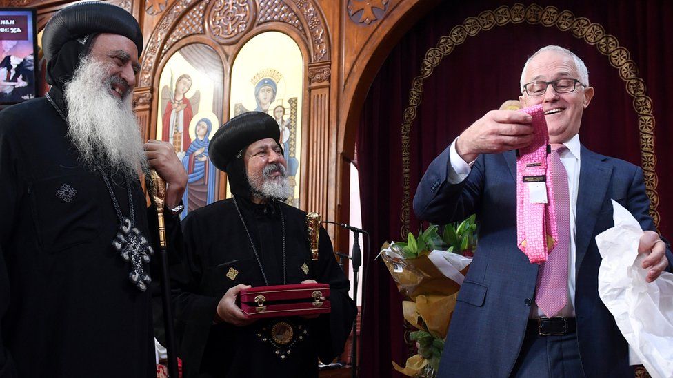 Australian Prime Minister Malcolm Turnbull looks at a Donald Trump branded tie given to him by Grace Bishop Paula, Diocese of Tanta in Egypt (left) and Coptic Orthodox Bishop Daniel during his visit to the St Mark Coptic Orthodox Church in Sydney, Australia, 25 June 2017