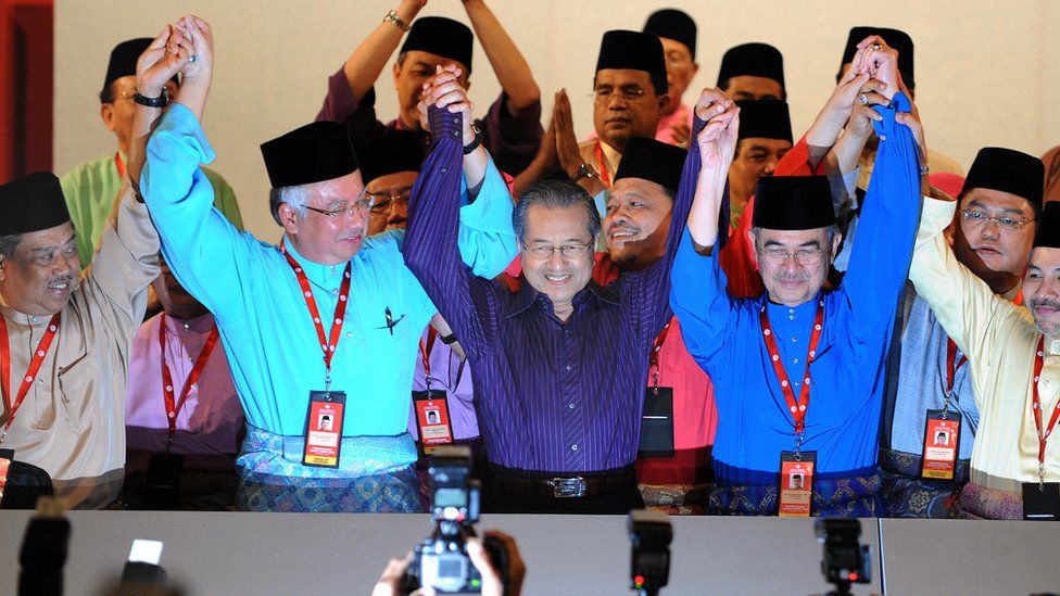 Mahathir Mohamad (C-front) raises the hands of Abdullah Ahmad Badawi (2nd R-front) and Najib Razak (2nd L-front) in Kuala Lumpur in 2009