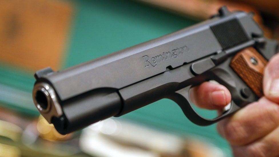 A salesperson holds a Remington handgun at Chuck"s Firearms in Atlanta, Georgia, USA, 13 February 2018.