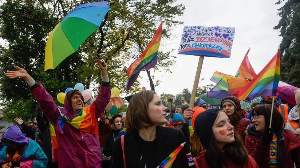 A woman holds a rainbow flag during an Equality/Pride march on October 06, 2019 in Nowy Sacz, Poland