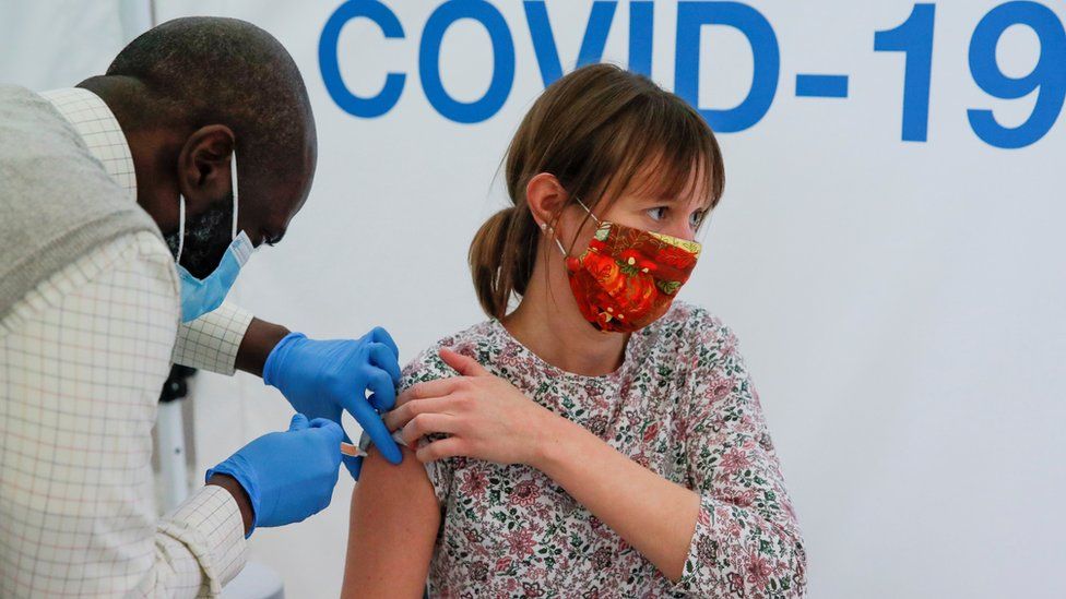 A woman receives a vaccine in a at Newmarket Racecourse