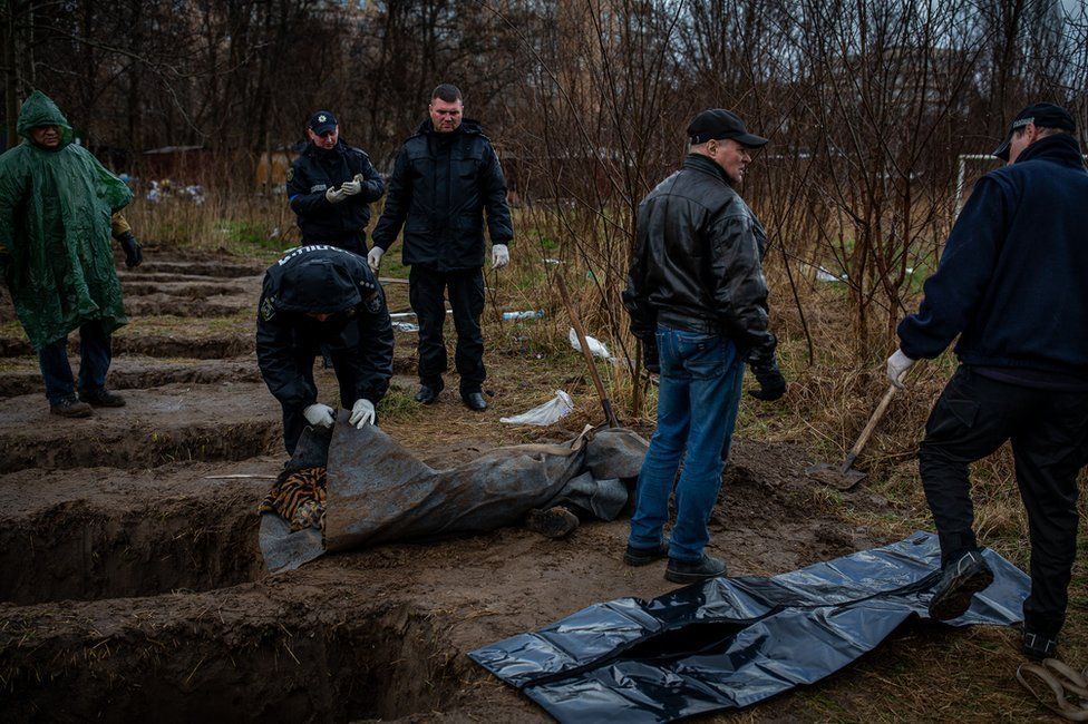 Nine graves, dug by neighbours behind apartment buildings in Bucha.