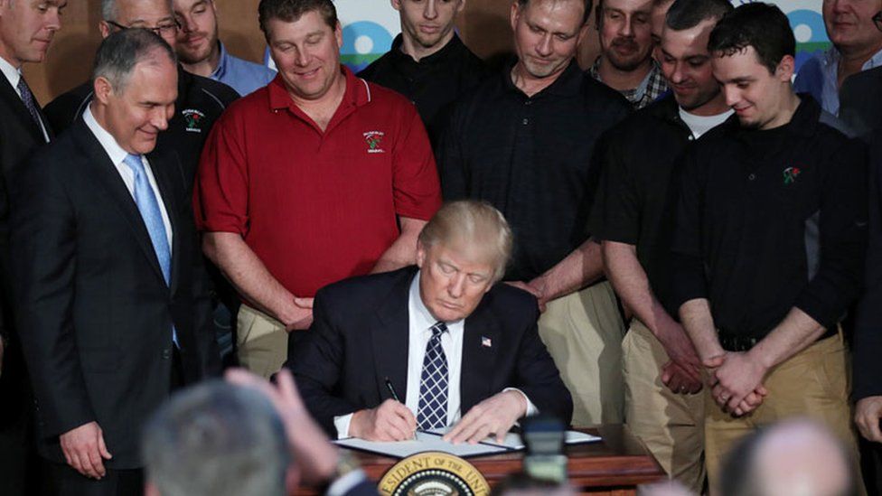Trump with miners signing the order