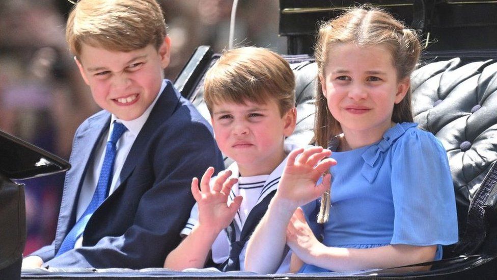 Prince George, Prince Louis, and Princess Charlotte ride in a carriage as the Royal Procession travels down The Mall to the Trooping the Colour ceremony