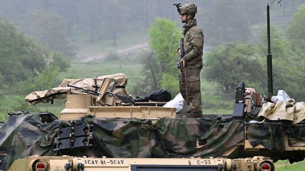 A US soldier stands on a US Army M1A2 Abrams tank during the Combined Resolve 18 exercise at the Hohenfels trainings area, southern Germany, on May 11, 2023