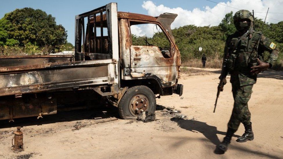 A Rwandan soldier walks in front of a burned truck near Palma, Cabo Delgado, Mozambique on September 22, 2021
