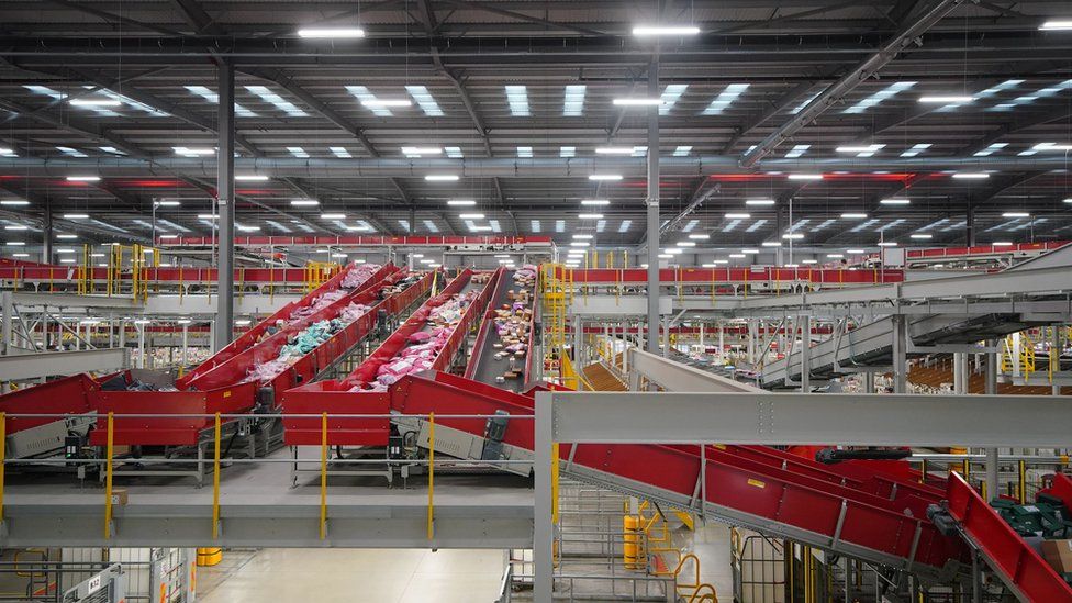 A royal mail sorting office, with belts full of parcels