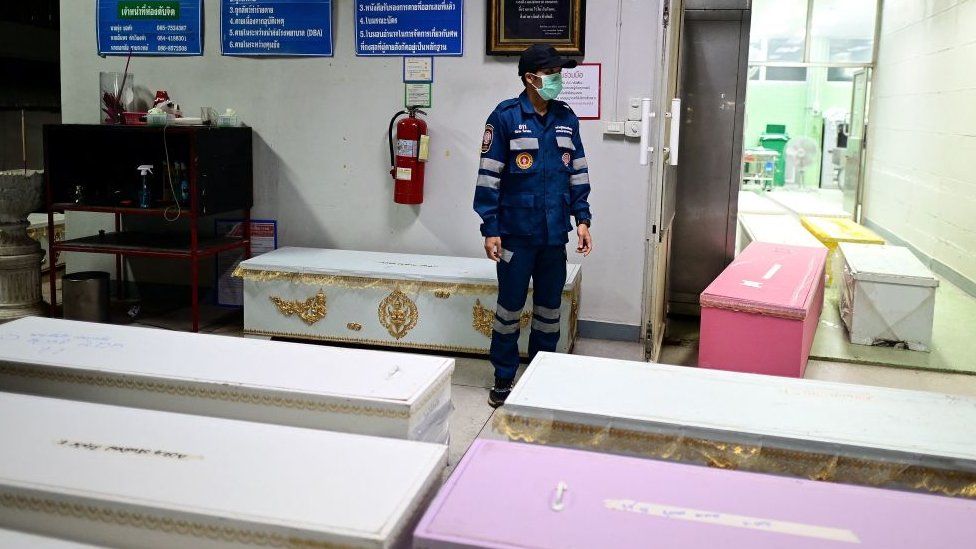 Rescue personnel count coffins carrying victims bodies at the hospital morgue in Udon Thani on October 7, 2022