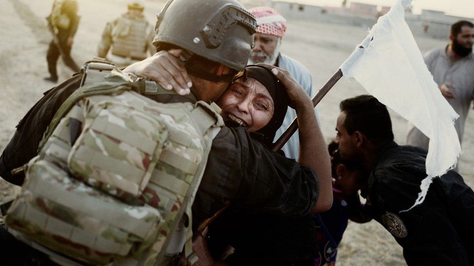 A female civilian hugs a solider after the Golden Division captured Bazwaya, the last village on the outskirts of Mosul (24 October 2016)
