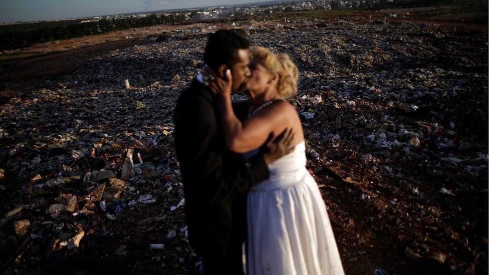 A couple of catadores de lixo, or recyclable material collectors, pose for a photo after their wedding at Lixao da Estrutural, Latin America's largest rubbish dump, in Brasilia, Brazil, 18 January 2018