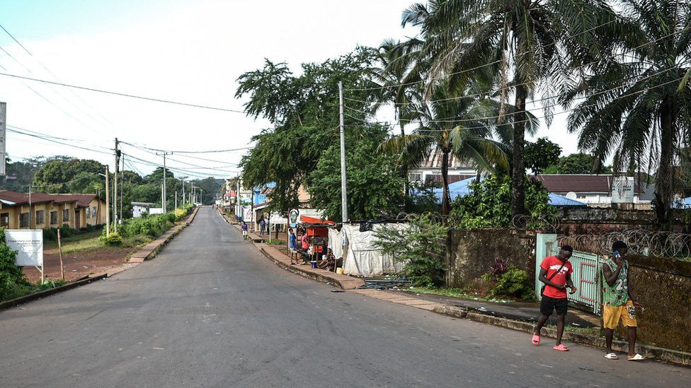 Two men walk Freetown's quiet streets during a curfew