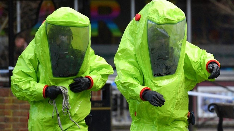 Two men in bright biohazard protective suits in the British city of Salisbury