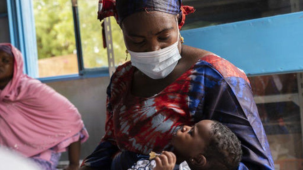 Rafatou holds her son while waiting for him to be vaccinated, at Gamkalé health centre, Niger