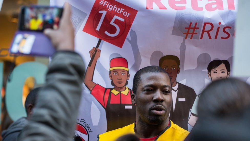 Retail Action Project and Fight for 15 activists march by stores, through a Chick fil A and through the Manhattan Mall on Black Friday, on November 27, 2015.