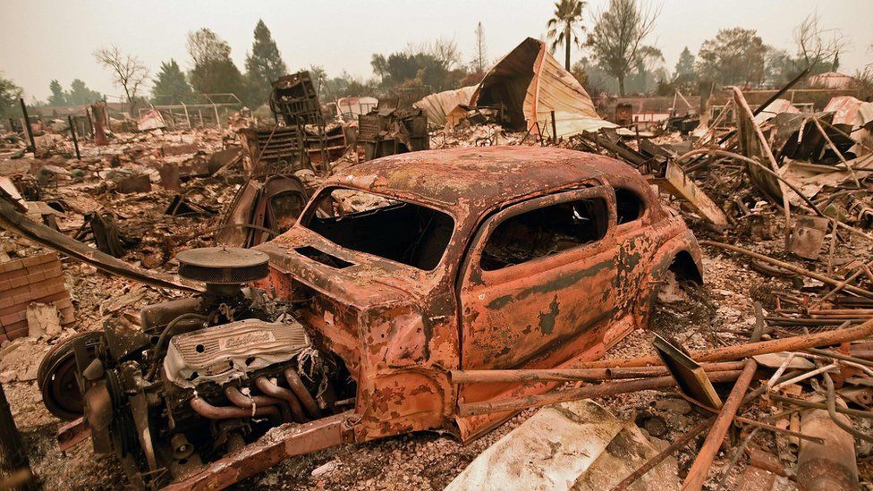 A destroyed car is seen among the ruins of a burned neighbourhood after the Carr fire passed through the area of Lake Keswick Estates near Redding, California on July 28, 2018