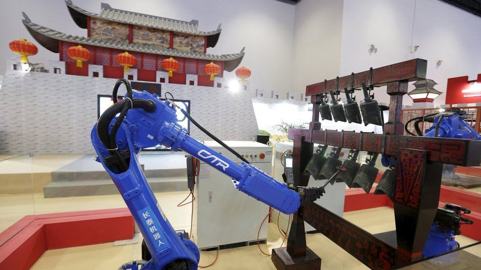 Two robots play Chinese ancient chime bells at the World Robot Exhibition, during the World Robot Conference in Beijing