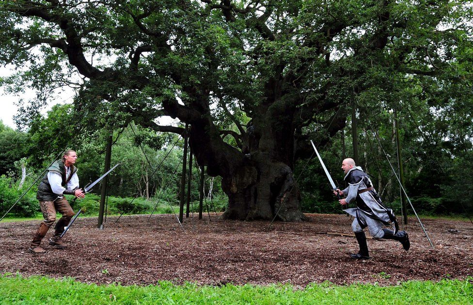 People posing as the Robin Hood and the Sheriff of Nottingham in front of the Major Oak