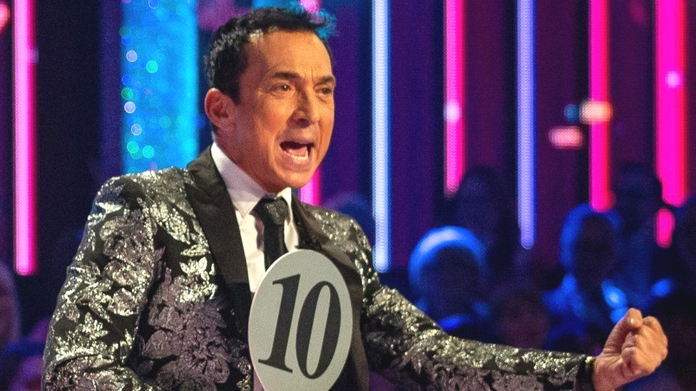 Bruno Tonioli holding up a 10 score paddle and punching a fist on Strictly Come Dancing