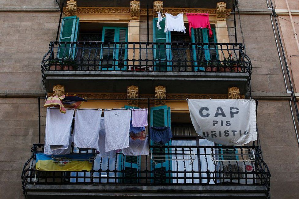 A banner reading "No tourist flats" hangs from a balcony to protest against holiday rental apartments for tourists in Barcelona on 24 November, 2016