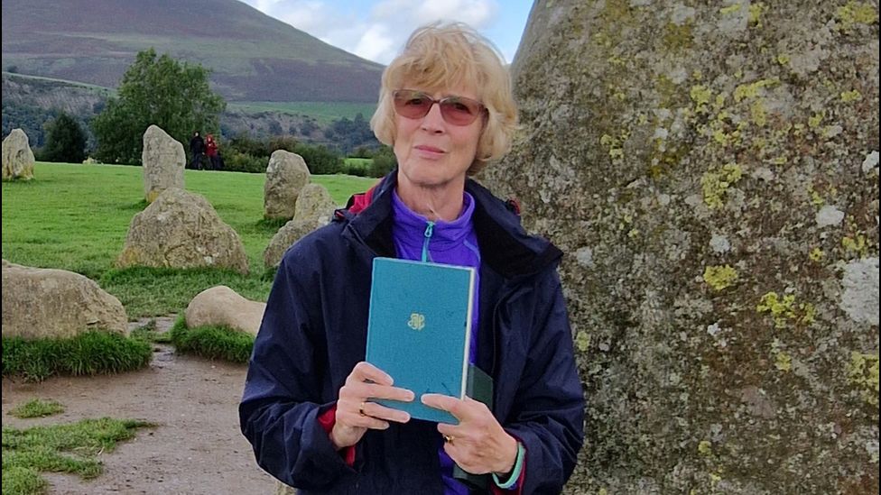 Ros Ford holding the copy of Texts and Pretexts