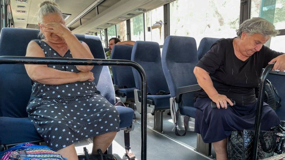 Два человека сидят на автобус.