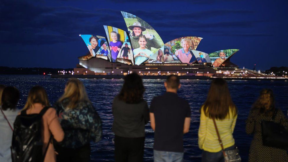 Мост Сидней-Харбор-Бридж освещен разными австралийскими лицами